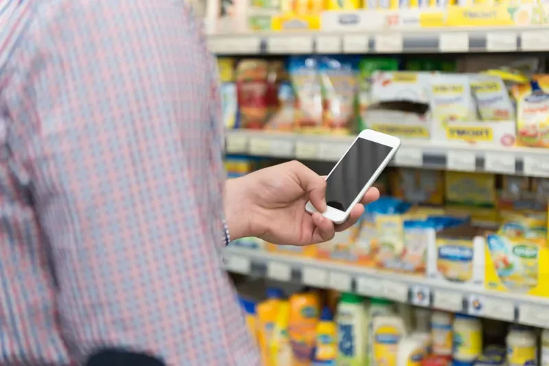 Man Using Mobile Phone Close-up While Shopping In Shopping Store